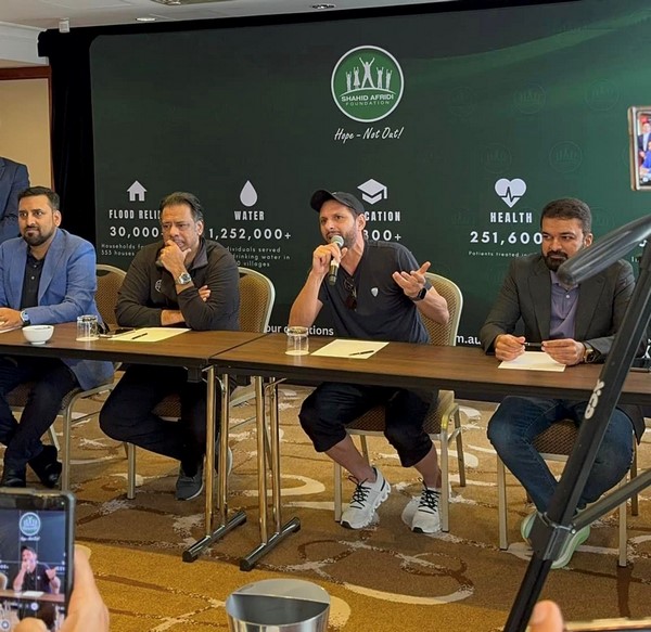 A group of men sitting at a table with microphones
Description automatically generated