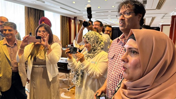 A group of people taking pictures
Description automatically generated