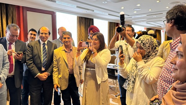 A group of people taking pictures
Description automatically generated