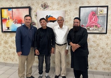 A group of men standing in front of a painting

Description automatically generated