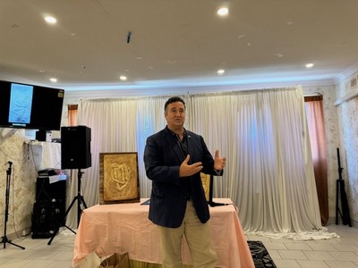 A person standing in front of a table with two hands

Description automatically generated