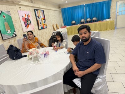 A person sitting at a table with a group of people

Description automatically generated
