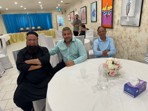 A group of men sitting at a table

Description automatically generated