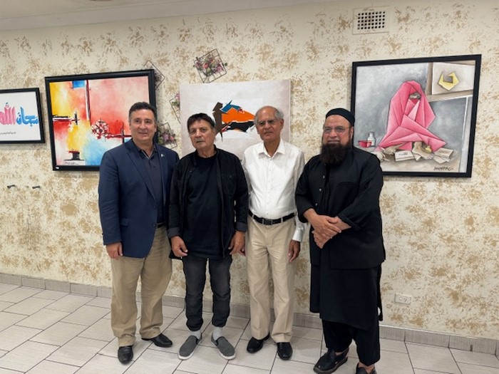 A group of men standing in front of a wall with paintings

Description automatically generated