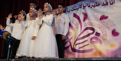 A group of people standing on a stage

Description automatically generated
