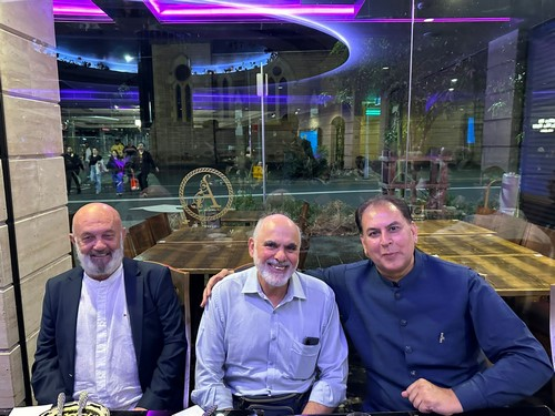 A group of men sitting at a table

Description automatically generated