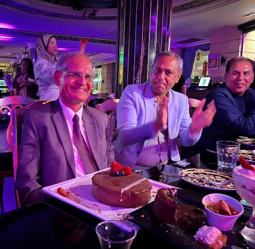 A group of people sitting at a table with food

Description automatically generated