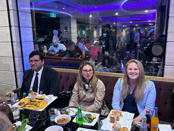 A group of people sitting at a table with food

Description automatically generated