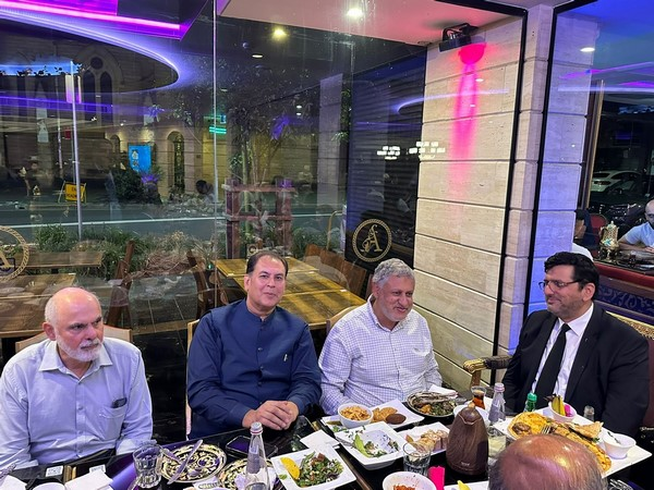 A group of men sitting at a table with food

Description automatically generated
