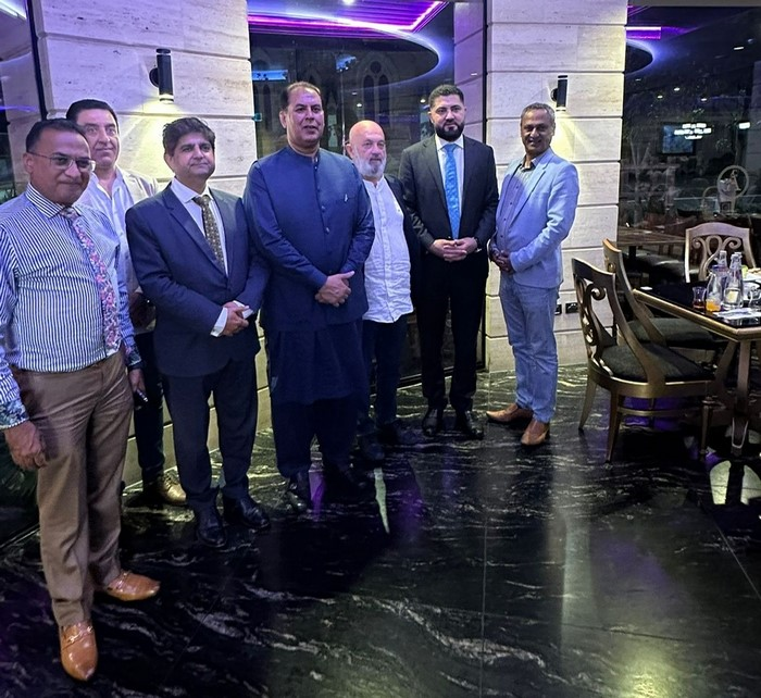A group of men standing in a room

Description automatically generated