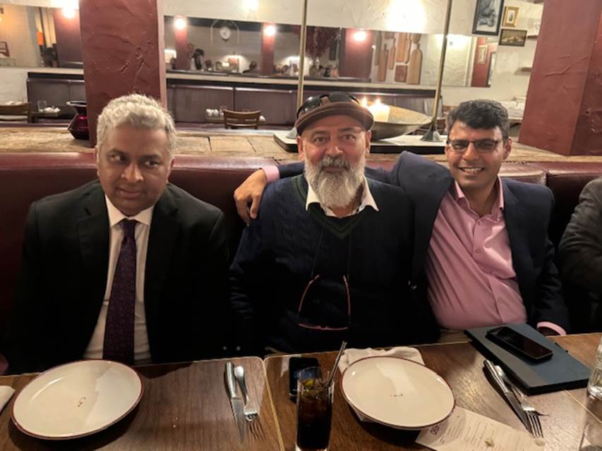 A group of men sitting at a table
Description automatically generated