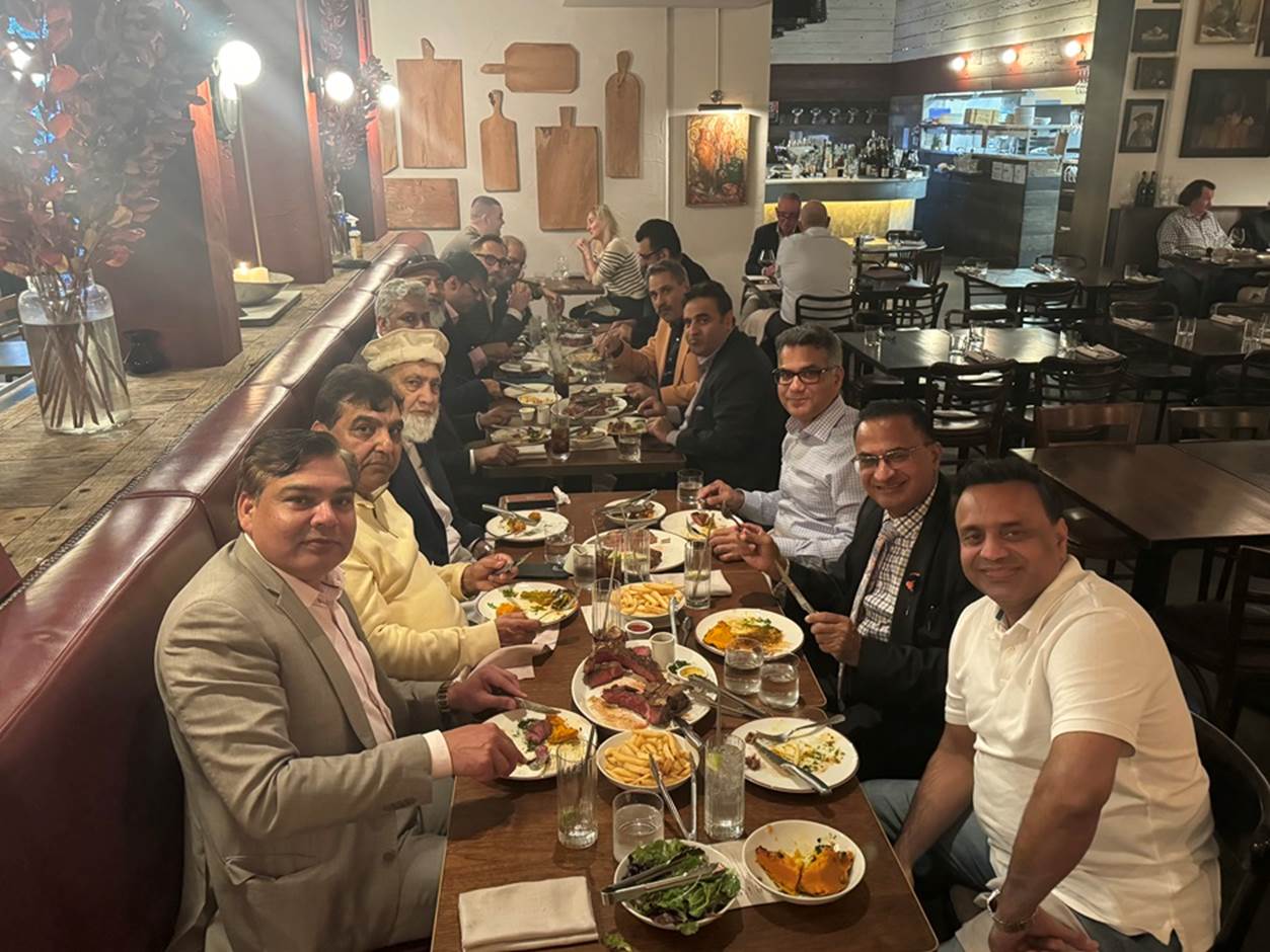 A group of people sitting at a table with food
Description automatically generated