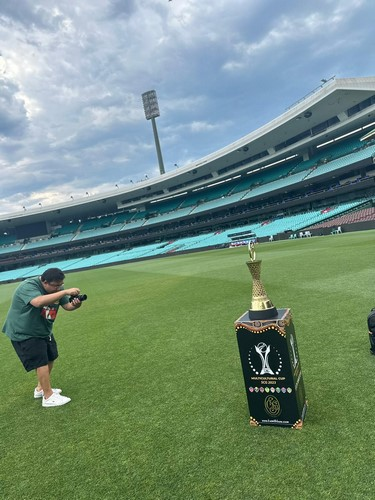 A person taking a picture of a trophy
Description automatically generated