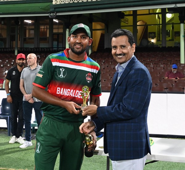 A person holding a trophy and smiling at the camera
Description automatically generated
