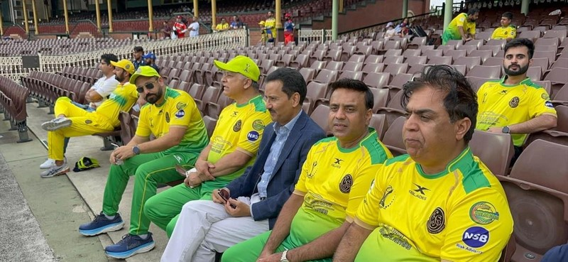 A group of men sitting in a stadium
Description automatically generated