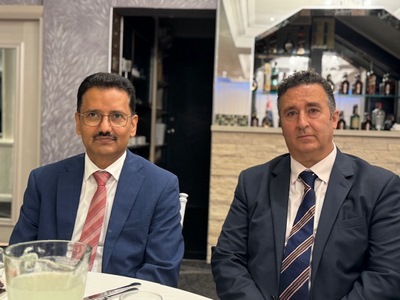 Two men sitting at a table
Description automatically generated
