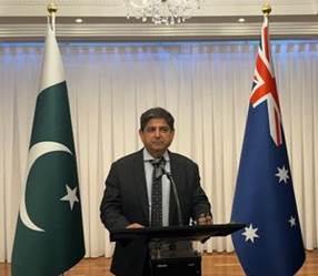 A person standing at a podium with flags behind him
Description automatically generated