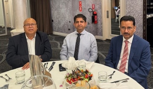 A group of men sitting at a table
Description automatically generated