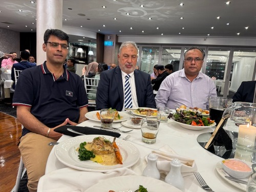 A group of men sitting at a table with food
Description automatically generated