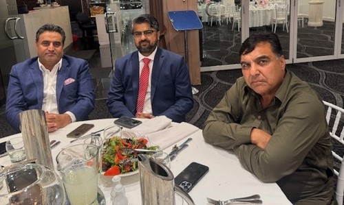 A group of men sitting at a table
Description automatically generated