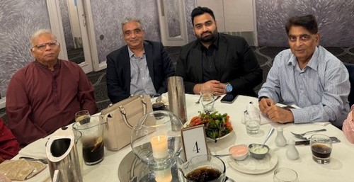 A group of people sitting at a table
Description automatically generated