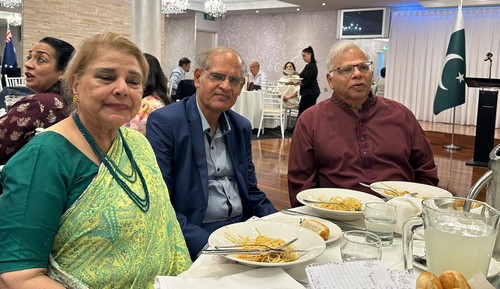 A group of people sitting at a table with plates of food
Description automatically generated