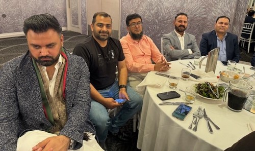 A group of men sitting at a table
Description automatically generated