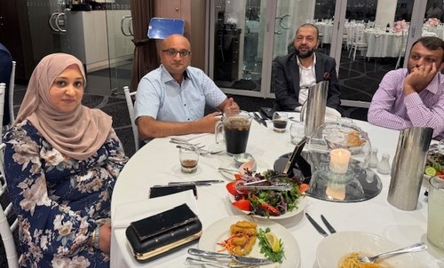 A group of people sitting at a table
Description automatically generated