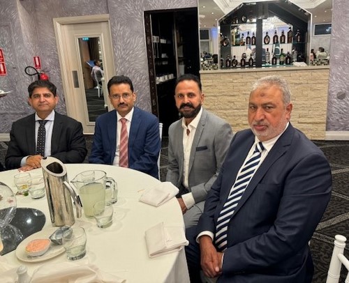 A group of men sitting at a table
Description automatically generated