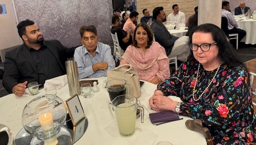 A group of people sitting at a table
Description automatically generated