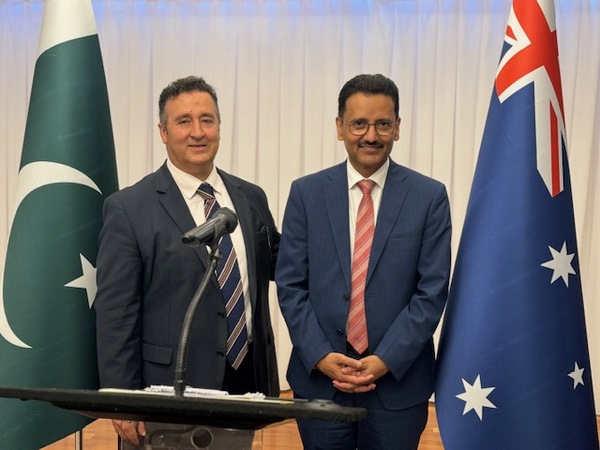 A couple of men standing in front of a podium
Description automatically generated