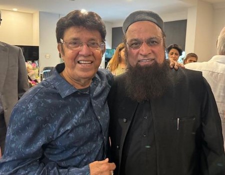 Two men standing together smiling
Description automatically generated