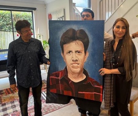A group of people holding a painting of a person
Description automatically generated