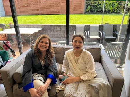 Two women sitting on a couch
Description automatically generated