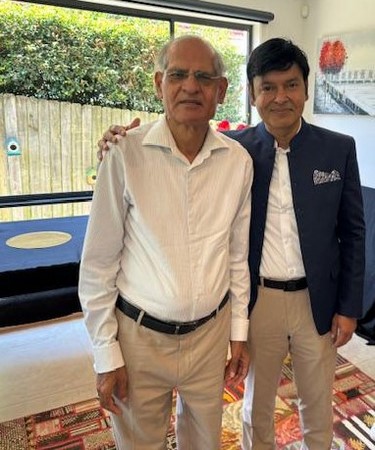 Two men standing next to each other
Description automatically generated