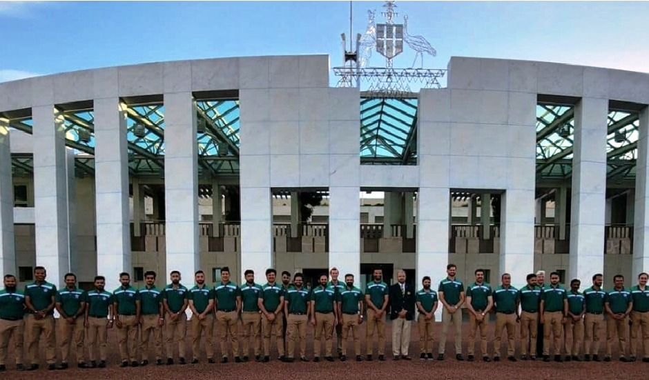 A group of men in uniform standing in front of a building
Description automatically generated