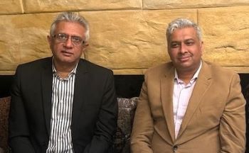 Two men sitting next to each other
Description automatically generated