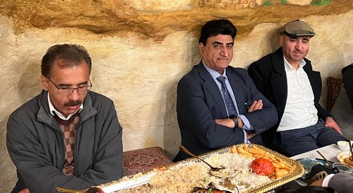 A group of men sitting at a table
Description automatically generated