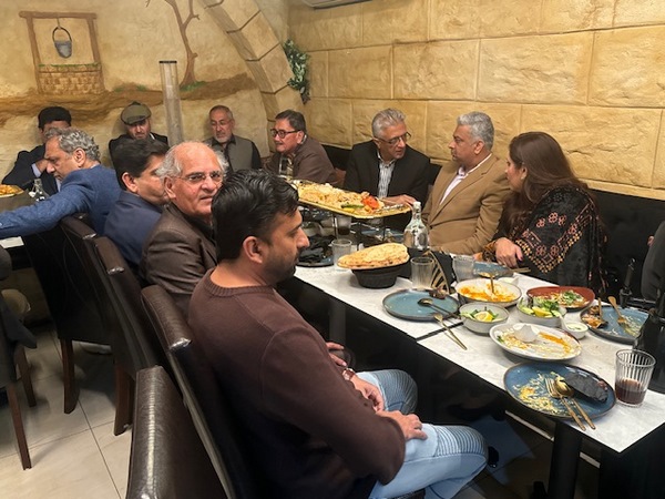 A group of people sitting at a table with food
Description automatically generated