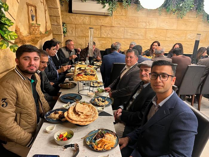A group of people sitting at a table with food on it
Description automatically generated