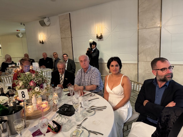 A group of people sitting at a table
Description automatically generated