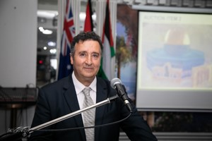 A person standing at a podium

Description automatically generated