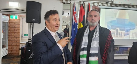A person in a suit and tie standing next to a person in a scarf

Description automatically generated