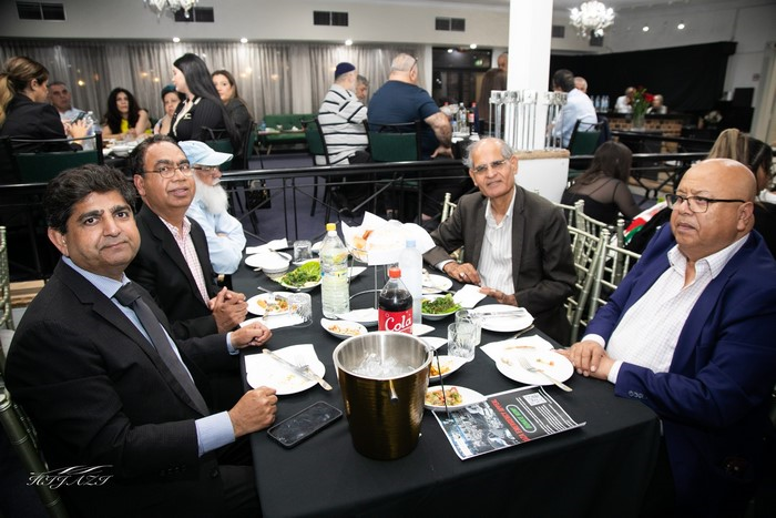 A group of men sitting at a table

Description automatically generated