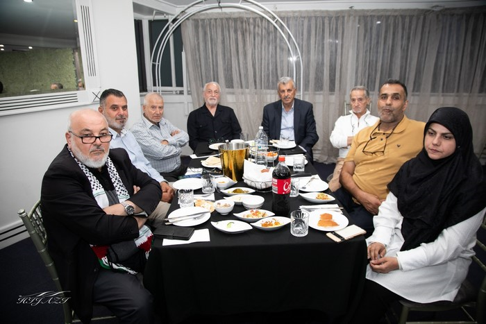 A group of men sitting around a table

Description automatically generated