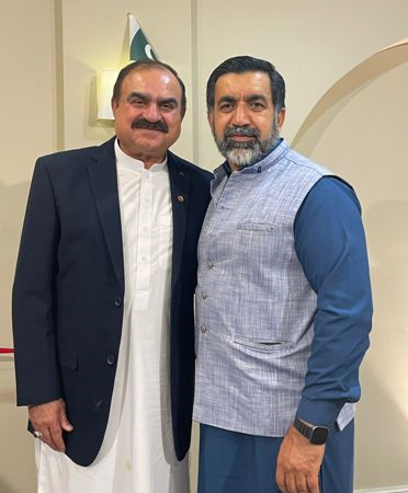 Two men standing together smiling

Description automatically generated