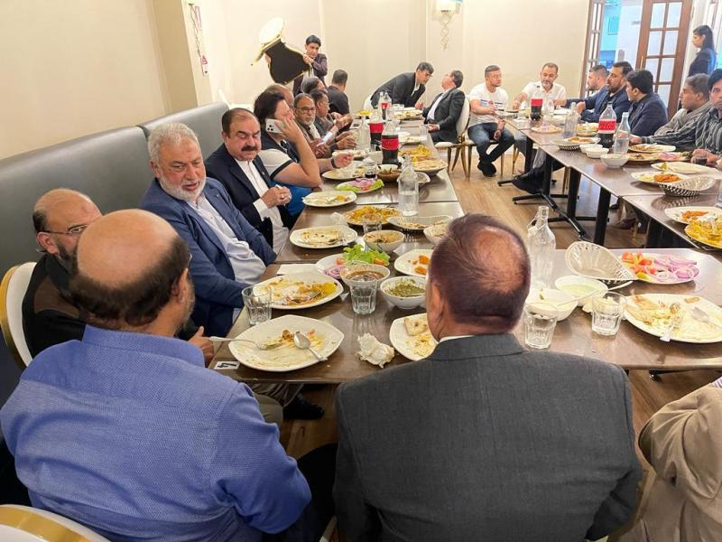 A group of men sitting at a table eating food

Description automatically generated