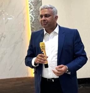 A person in a suit holding a microphone
Description automatically generated