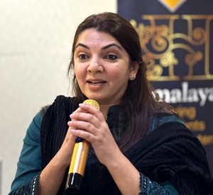 A person speaking into a microphone
Description automatically generated