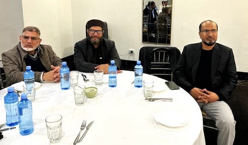 A group of men sitting at a round table
Description automatically generated